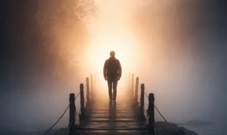 Ein atmosphärisches Hochformat-Bild zeigt eine einzelne Person, die auf einem schmalen Holzsteg steht und in eine helle, nebelverhangene Lichtquelle in der Ferne blickt. Der Steg führt über ruhiges Wasser und wird von dunklen Holzpfosten mit Seilen begrenzt. Links und rechts rahmen schemenhafte Bäume die Szene ein, deren Äste im dichten Nebel verschwimmen. Das Licht am Ende des Stegs wirkt warm und golden, während der Vordergrund in kühlen, dunkleren Blau- und Grautönen gehalten ist – ein starker Kontrast zwischen Klarheit und Ungewissheit. Oben links steht in großer, orangefarbener Schrift „Resonanzbrief März 2026“, rechts oben ist dezent das Logo „Stephan A. Davis“ sichtbar. Am unteren Rand befindet sich der Leitsatz „ehrlich verbinden – klar entscheiden – bewusst wirken“. Das Bild vermittelt eine ruhige, nachdenkliche Stimmung und symbolisiert Übergang, Orientierung und den Weg vom Sichtbaren ins Ungewisse – hin zu etwas, das sich erst im Weitergehen erschließt.